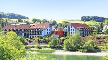 Außenansicht auf Göbel's Seehotel Diemelsee und die umliegende grüne Landschaft.